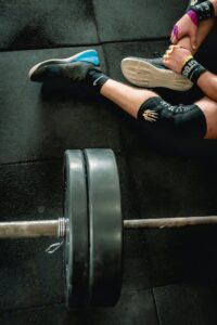 Close-up of an athlete in gym with weights focusing on fitness and strength.