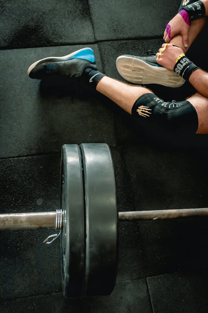 Close-up of an athlete in gym with weights focusing on fitness and strength.